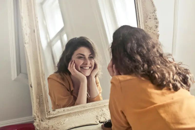 Donna che si osserva il viso allo specchio | LaserMilano